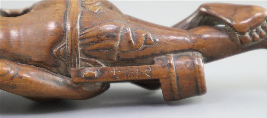 A Japanese cherrywood okimono netsuke of a farmer, early 19th century, 15cm long